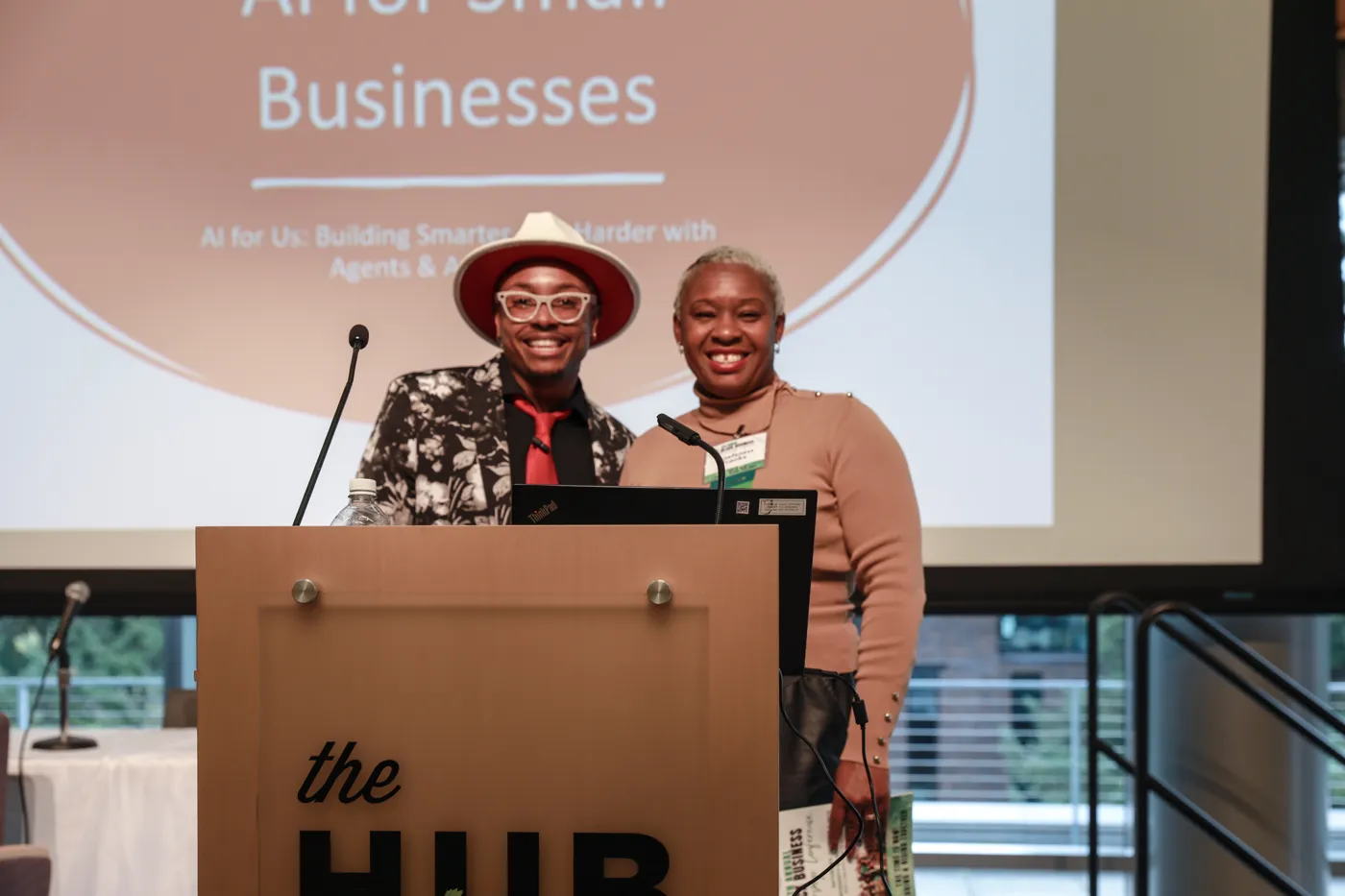 D co-presenting at a podium at The HUB